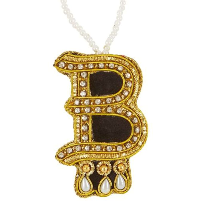 A letter B hanging decoration embroidered in gold and finished with beads. With three faux pearls.