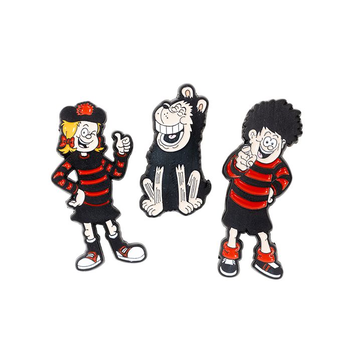 A set of three enamel pin badges in the shape of Beano characters, Dennis, Gnasher and Minnie in black and red. 