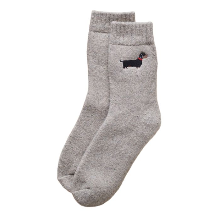 A pair of taupe-coloured wool socks with a black Dachshund wearing a red collar embroidered on the ankle.
