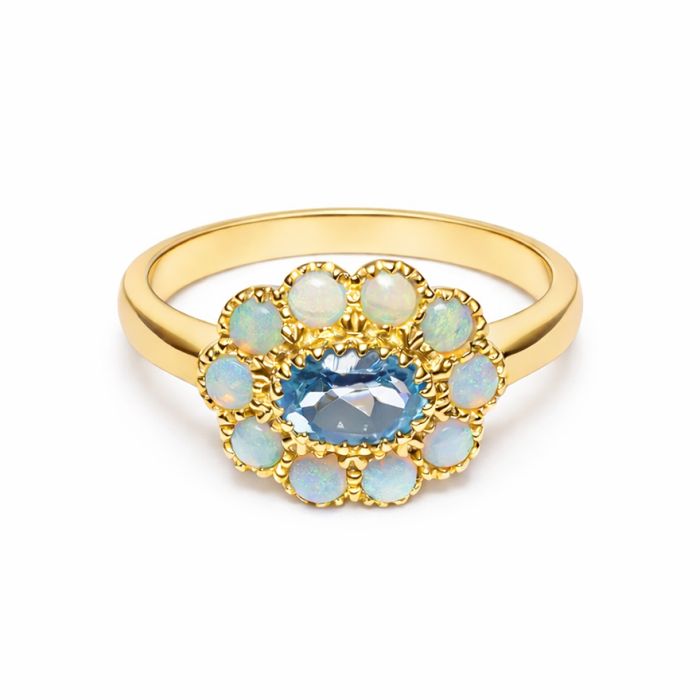 A yellow gold ring with a central blue topaz stone, surrounded by 10 turquoise opals.