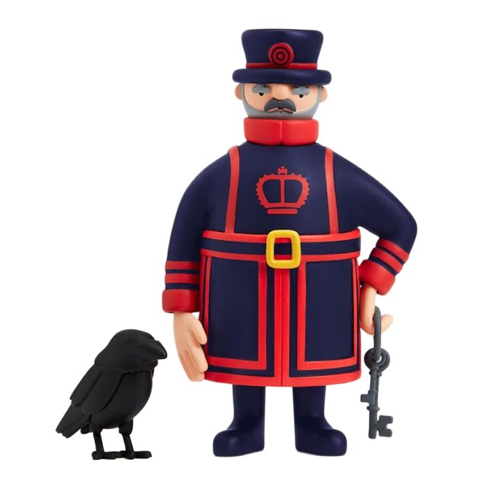 A Beefeater figurine in a red and navy uniform holding a set of medieval keys. Alongside is a little black raven model.
