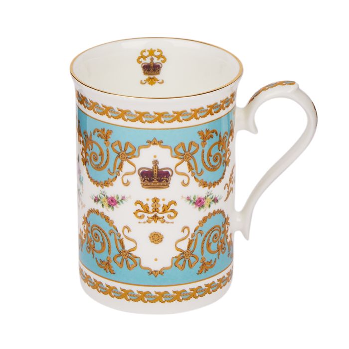A turquoise and white mug with a gold pattern, a crown and roses design