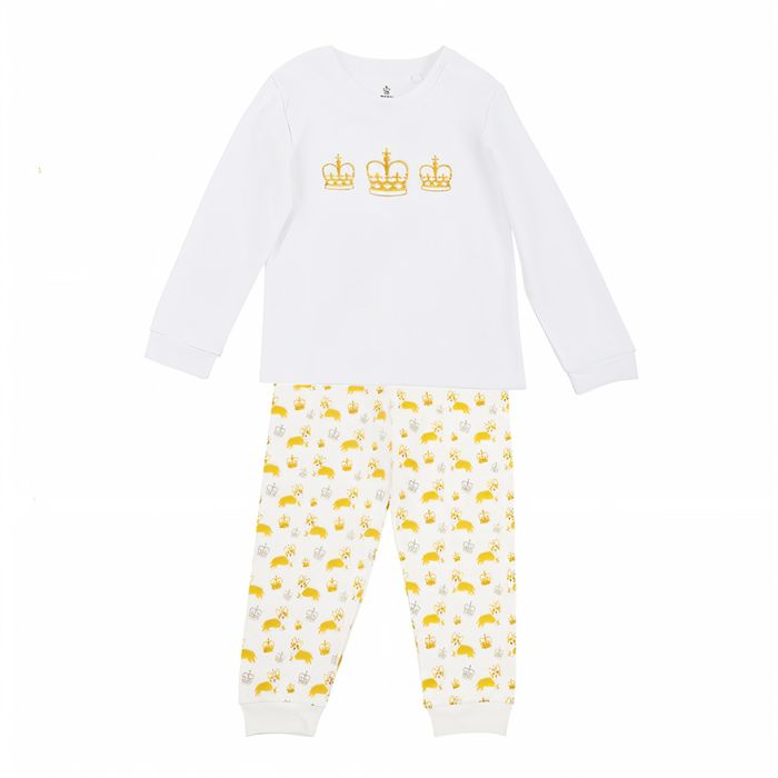 A set of children's pyjamas with a white long-sleeved top, and three gold crowns printed on the chest. The bottoms feature an all-over pattern of corgi dogs and crown.