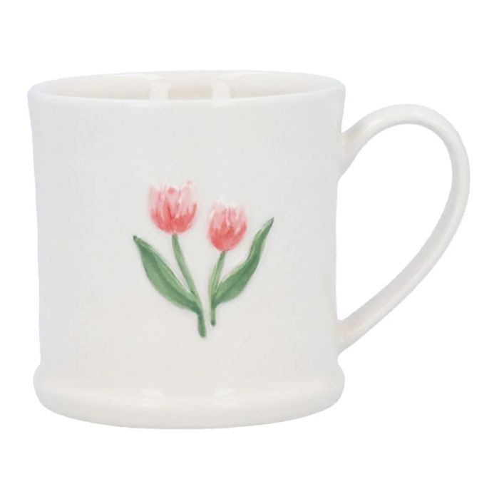 A white ceramic mini mug with handle, finished with two embossed tulips on one side in pink with green stalks. 