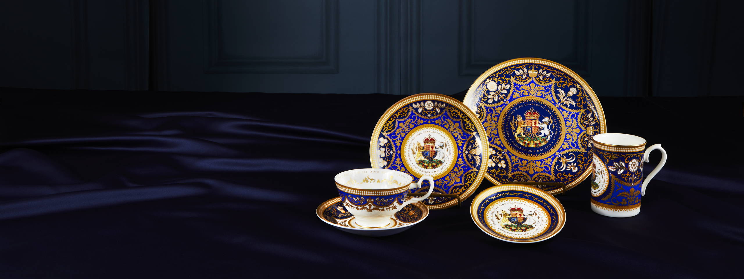 King Charles III Coronation commemorative china set in royal blue and gold with ornate crest detailing.