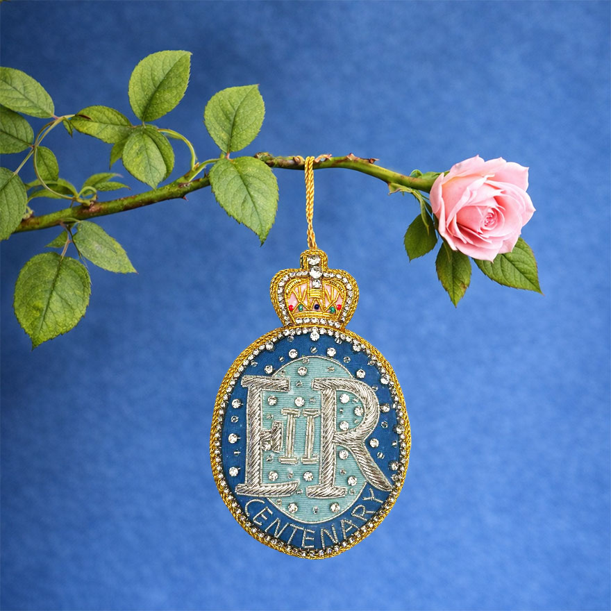 Queen Elizabeth II centenary decoration hanging from a pink rose branch. 